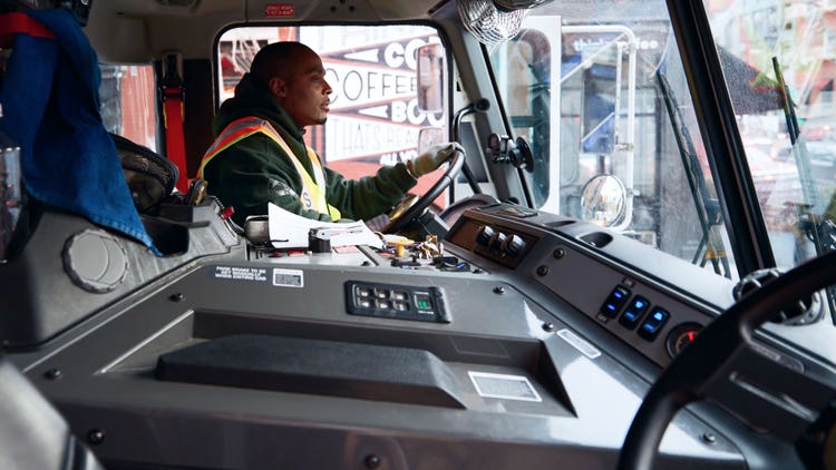Sideview closeup of a driver holding the steering wheel.