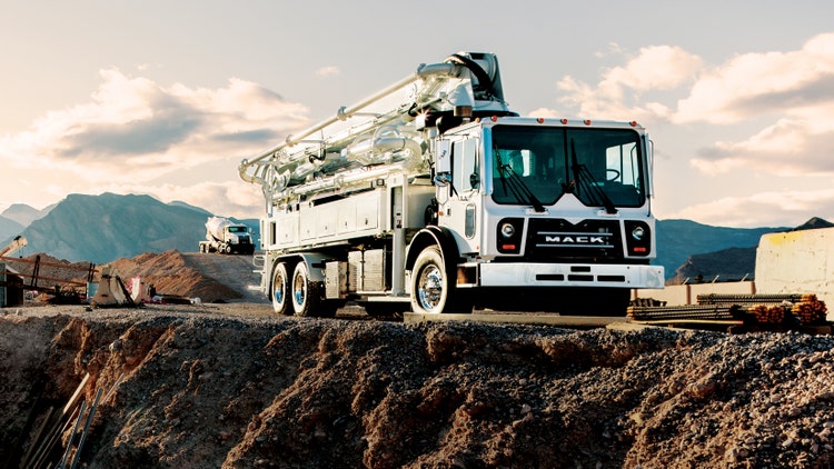 White Mack TerraPro truck with a concrete pump, parked on a construction site